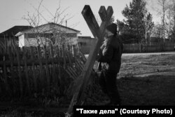 Father Mikhail raises the cross thrown by the builders.