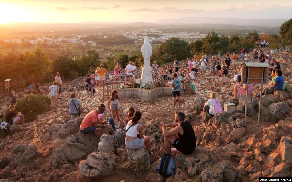 Pilgrims gather around a statue of Mary at the site where several children reported seeing her appear in the summer of 1981.