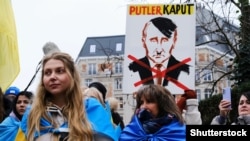 Плакат із зображенням президента Росії Володимира Путіна у вигляді Адольфа Гітлера під час акції на підтримку України біля штаб-квартири Євросоюзу в Брюсселі, Бельгія, 23 січня 2023 року 