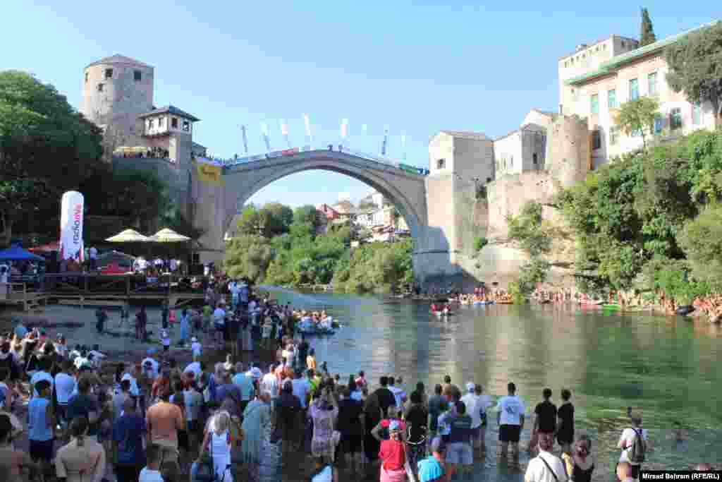 People gather to watch divers plunge into the waters of the Neretva River from the 16th-century Mostar Bridge, a marvel of Ottoman-era architecture, on July 28. Bosnia-Herzegovina is commemorating the 20th anniversary of the rebuilding of the bridge, one of the most important Ottoman monuments in the Western Balkans.