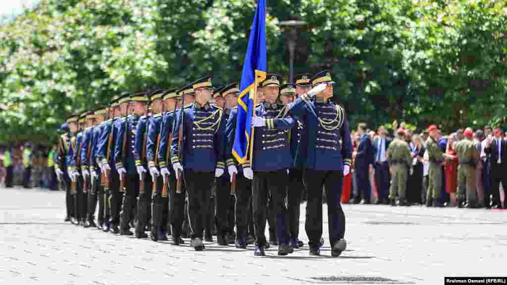 Pripadnik jedinice kosovske policije drži zastavu Kosova dok sa ostalim službenicima paradira na Trgu u Prištini 12. juna 2024. godine, u čast Dana oslobođenja zemlje.