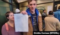 Broderic cu documentul în care îi erau indicate actele necesare obținerii permisului de ședere, scris exclusiv în română.