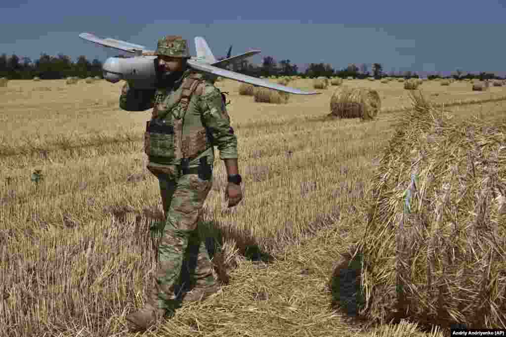 A soldier of Ukraine&#39;s National Guard 15th Brigade carries a Leleka reconnaissance drone in a wheat field near the front line in the Zaporizhzhya region, Ukraine.