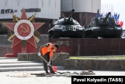 Un angajat al primăriei repară trotuarul de lângă monumentul dedicat celui de-Al Doilea Război Mondial din Belgorod, pe 5 mai.