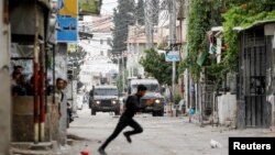 Palestinac bježi usred sukoba s izraelskim trupama tokom izraelske racije u Nablusu na Zapadnoj obali, 13. juni 2023.