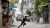 Një palestinez duke vrapuar në rrugë gjatë përplasjeve me trupat izraelite në Bregun e pushtuar Perëndimor, 13 qershor 2023.