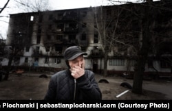 Мужчина на фоне его сгоревшего дома. Он решил остаться. Северодонецк, апрель 2022 года