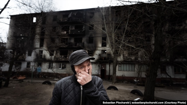 Мужчина на фоне его сгоревшего дома. Он решил остаться. Северодонецк, апрель 2022 года