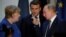 Former German Chancellor Angela Merkel (left) talks with Russian President Vladimir Putin (right) and Fench President Emmanuel Macron looks on. (File photo)