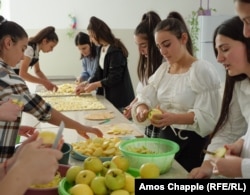 Diana Karapetian (on right, holding apple) and other senior students prepare apples grown in the school for drying.