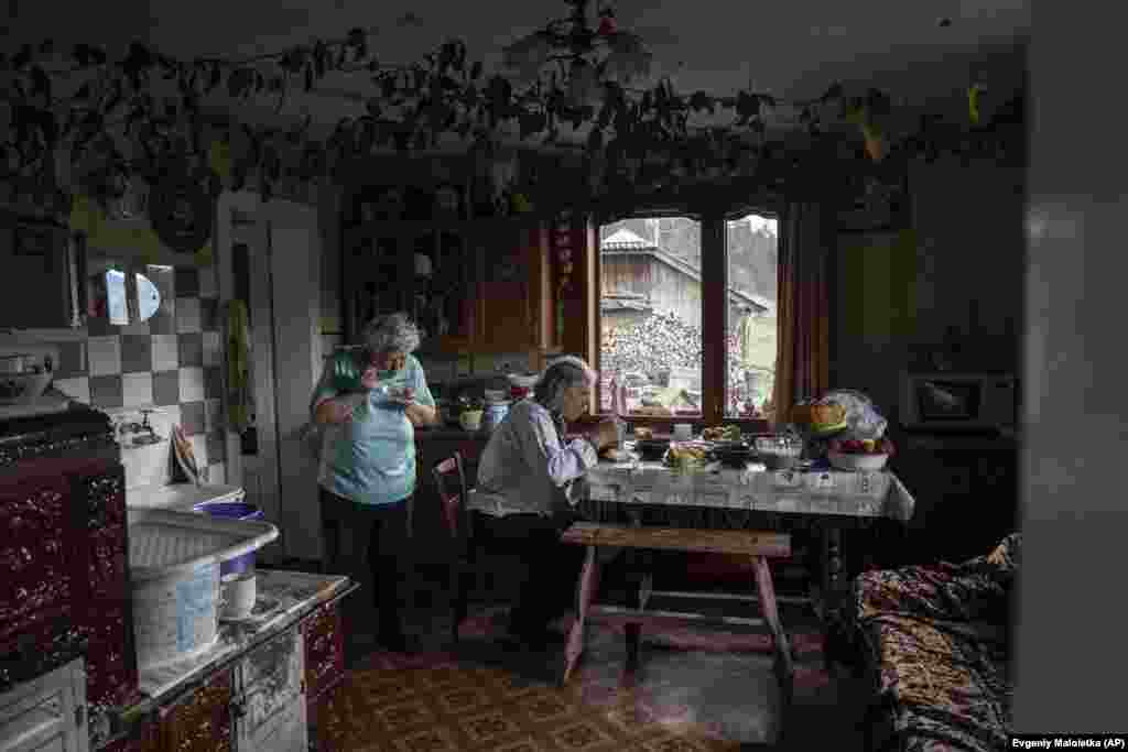 Иван и Мария Зеленчук обедают на кухне перед началом рождественских торжеств в селе Криворивня на западе Украины, 25 декабря 2023 года. Село в Карпатах считается местом проживания гуцульского меньшинства Украины, которое хранит свои традиции