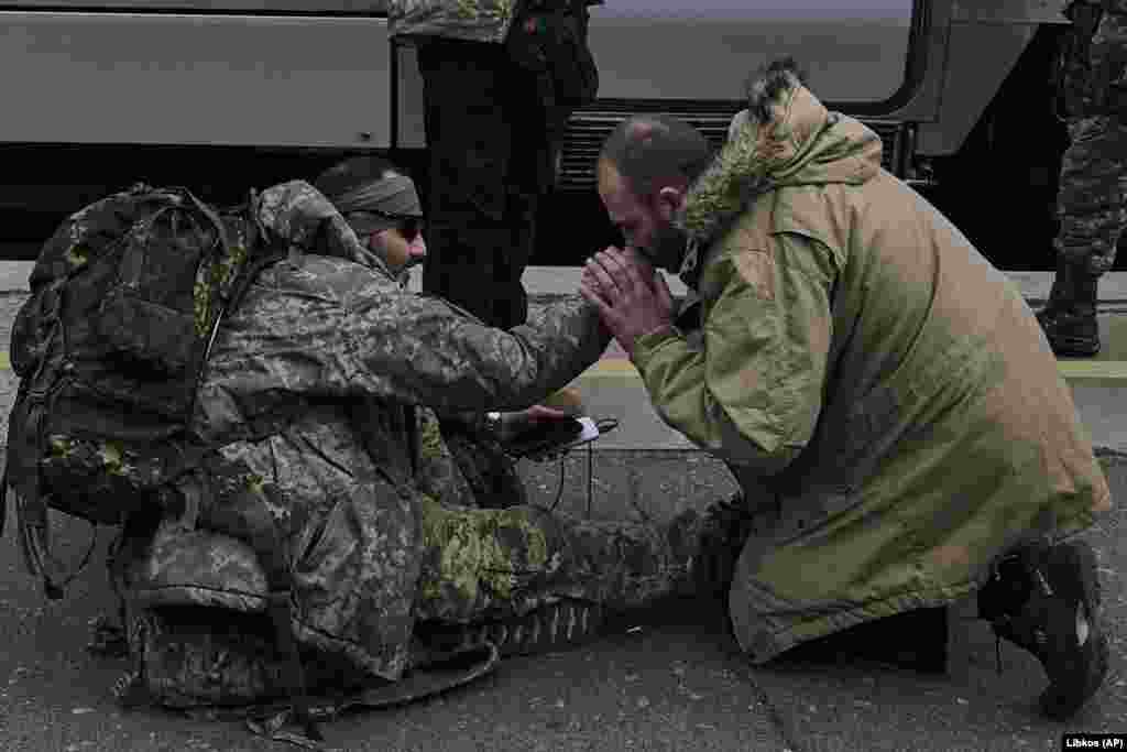 A man kisses a Ukrainian soldier&#39;s hand to thank him at a railway station in Kramatorsk, Donetsk region, Ukraine.