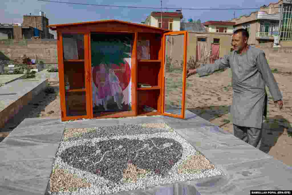 Muškarac otvara vrata biblioteke na grobu Marzije (18) i Hadžare (19) u Kabulu. Dvije rođakinje ubijene su, nakon bombaškog napada samoubice&nbsp;među desetinama drugih studenata, većinom žena, koji su se okupili na prijemnom ispitu na univerzitetu u Kabulu u septembru 2022. godine. U znak počasti djevojčicama, njihove porodice su postavile biblioteku sa njihovim omiljenim knjigama na njihov grob na groblju u oblasti Dasht-e-barchi.