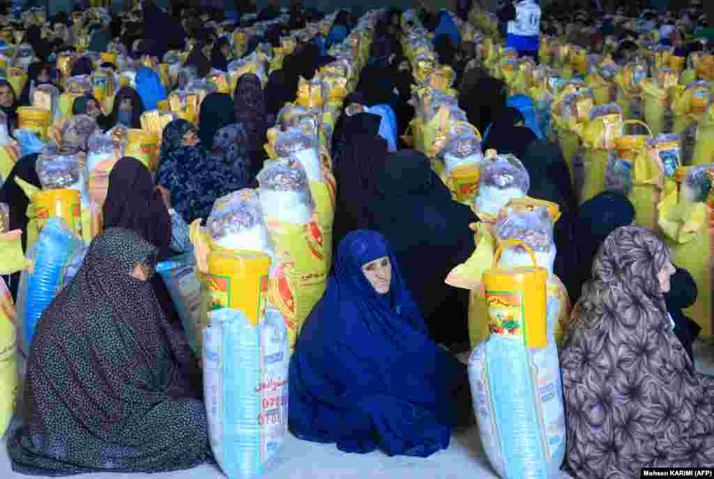  Afghan women receive food from a local charity during the Islamic holy fasting month of Ramadan in Herat Province. &nbsp; 