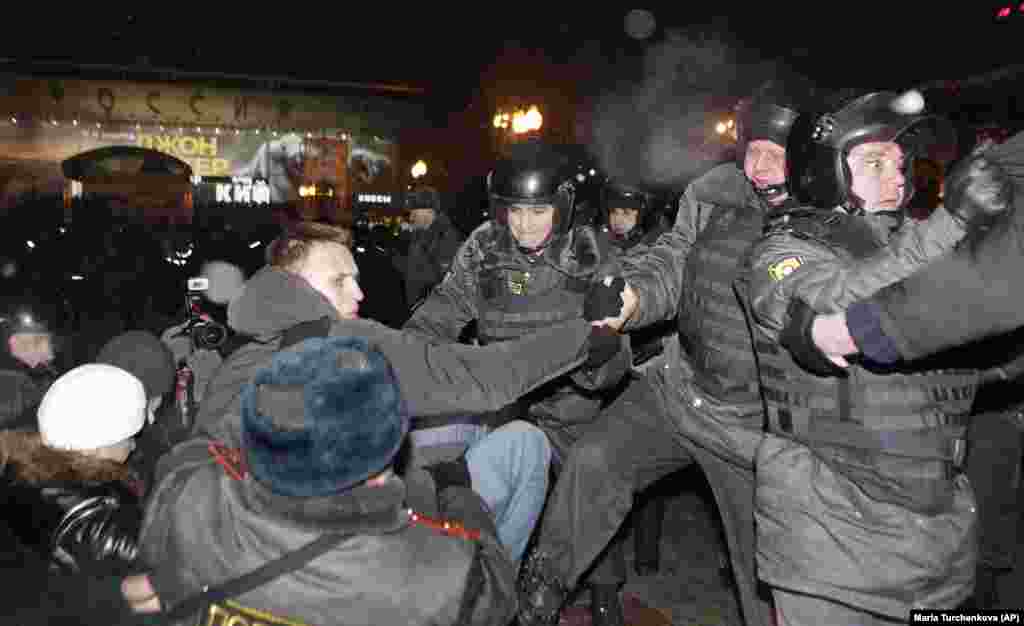 Полицијата го приведе Навални (лево) на митинг во Моксва, 5 март 2012 година, откако Владимир Путин беше прогласен за победник на претседателските избори. Навални ја опиша партијата на Путин, Единствена Русија, како &bdquo;партија на измамници и крадци&ldquo;.