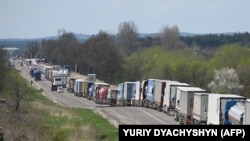 Camioane ucrainene așteaptă să intre în Polonia, una din principalele rute alternative de export, create de UE în 2022, după ce invazia rusă a dus și la blocarea porturilor ucrainene la Marea Neagră. Rava-Ruska, granița ucraino-poloneză, 18 aprilie 2023.