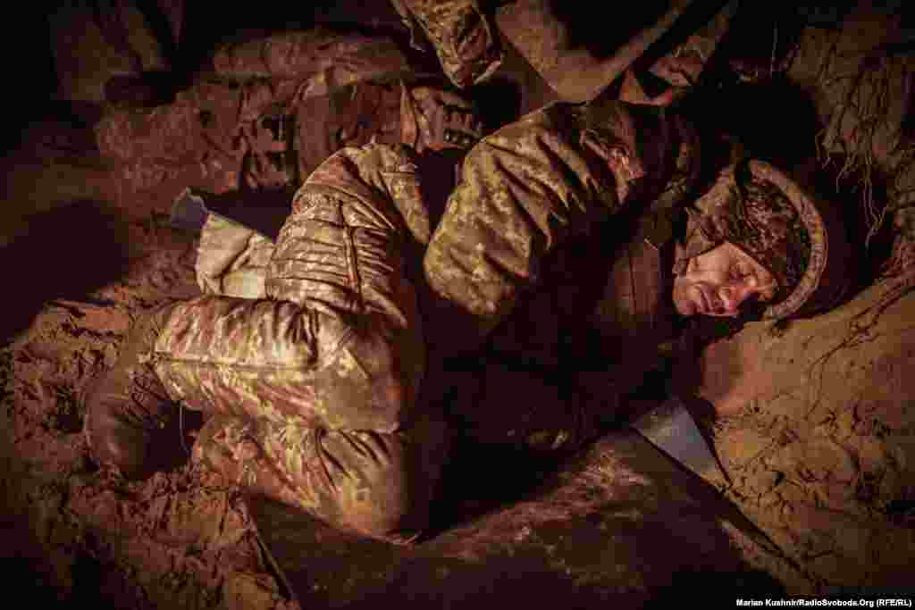 Një ushtar duke bërë një sy gjumë gjatë një qetësie në granatimet. Korrespondenti i Radios Evropa e Lirë, Maryan Kushnir, vizitoi forcat e Ukrainës pranë Kupijanskut në verilindje të Ukrainës, ku po e luftojnë artilerinë ruse dhe të ftohtit. &nbsp;