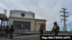 Тази снимка, направена на 20 май 2022 г., показва руски военнослужещи, които стоят на стража пред ВЕЦ "Каховка"