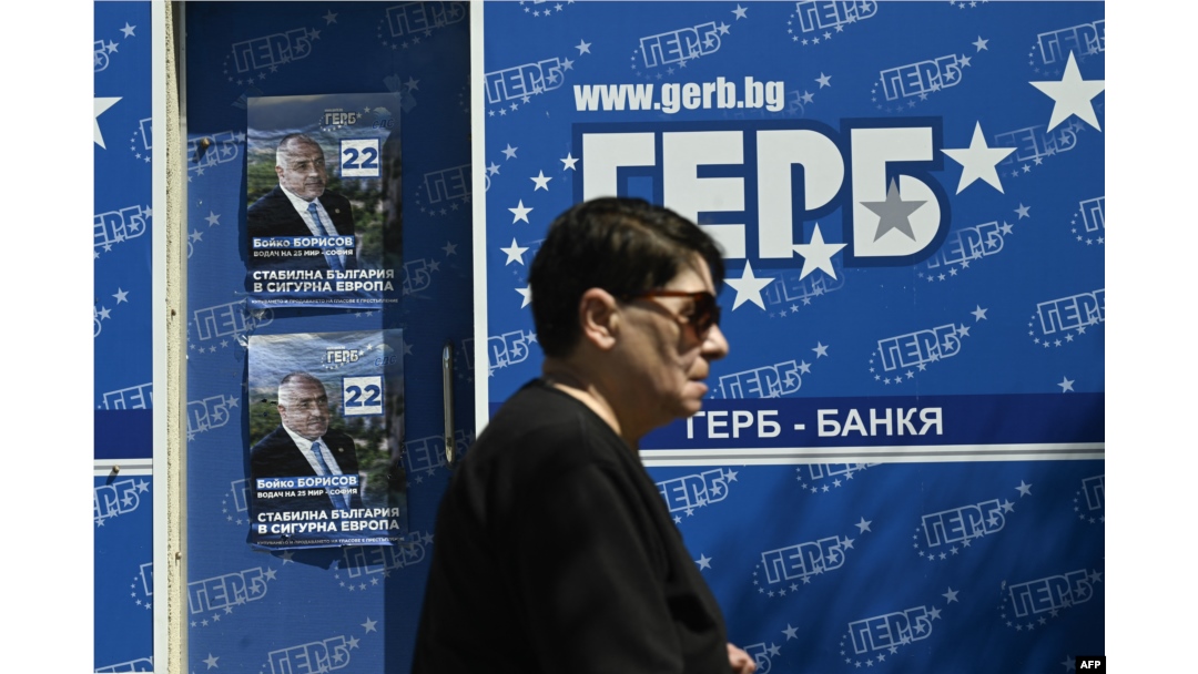 O femeie trece pe lângă afișe de campanie pentru partidul de centru-dreapta GERB din Bulgaria, la Sofia, pe 7 iunie 2024.