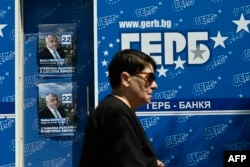 A woman walks past campaign posters for Bulgaria's center-right GERB party in Sofia on June 7.