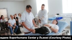 Французькі хірурги та українські лікарі оглядають пораненого бійця у Львові в центрі Superhumans