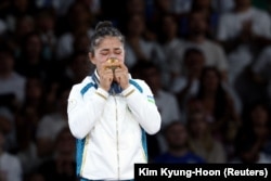 Diyora Keldiyorova of Uzbekistan celebrates on the podium in Paris on July 28.