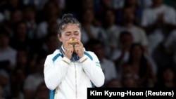 Gold medalist Diyora Keldiyorova of Uzbekistan rejoices on the podium after becoming the champion in the 52-kilogram judo competition.