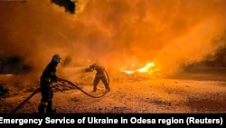 Firefighters extinguish burning trucks damaged during a Russian drone attack on a port in Ukraine's Odesa region.