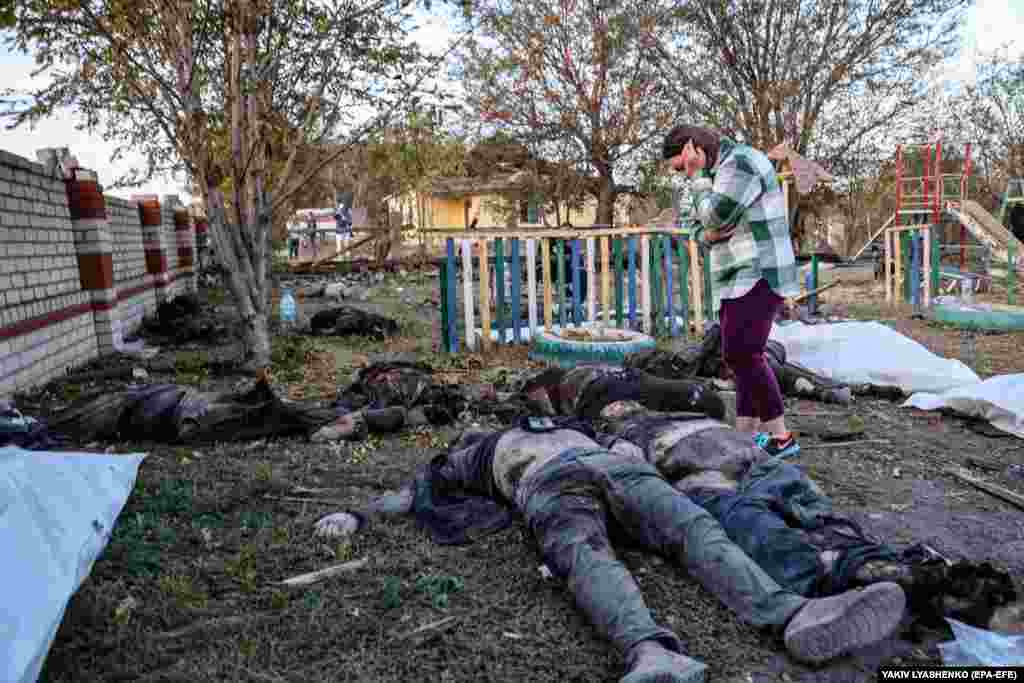 A local woman looks over bodies of the victims.