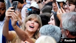 Американската поп ѕвезда Тејлор Свифт прави селфи со обожавателка на меѓународниот аеродром во Торонто, септември 2022 година.
