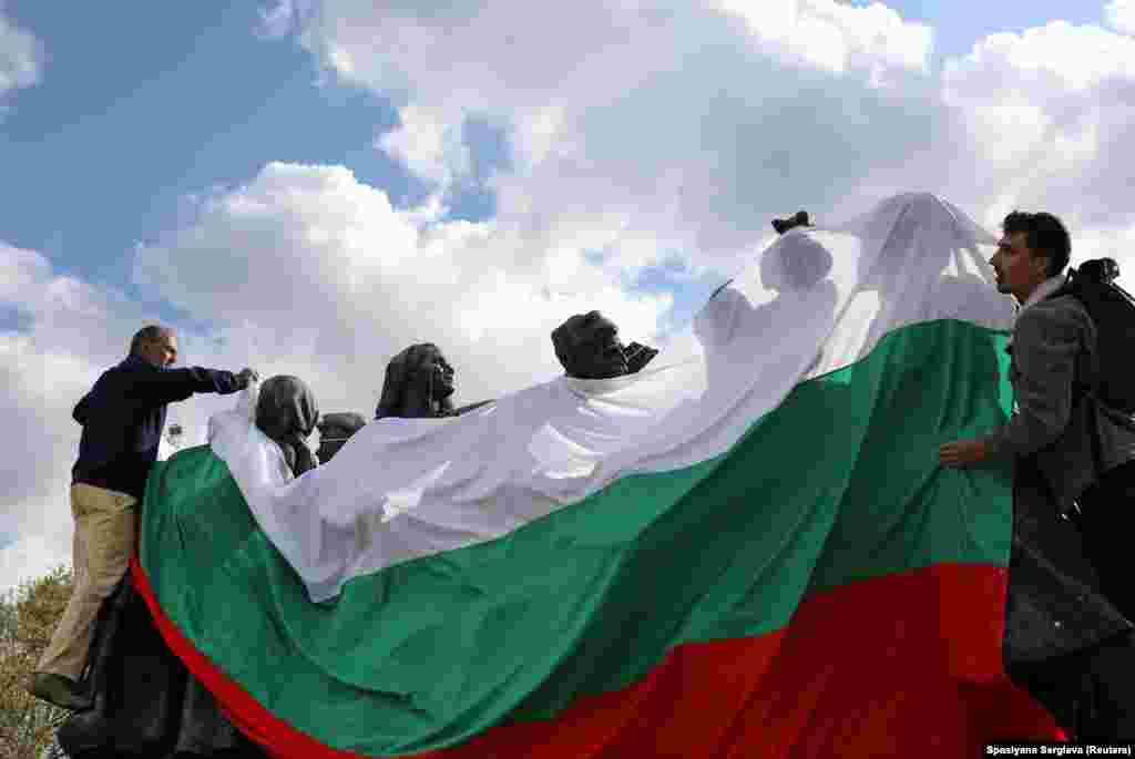 Activists wrap a Soviet sculptural ensemble in the Bulgarian flag on May 4, 2022. Public opinion in 2019, before the invasion of Ukraine, showed that more than two-thirds of Bulgarians saw communist-era monuments as important for Bulgaria&#39;s &quot;national identity.&quot;