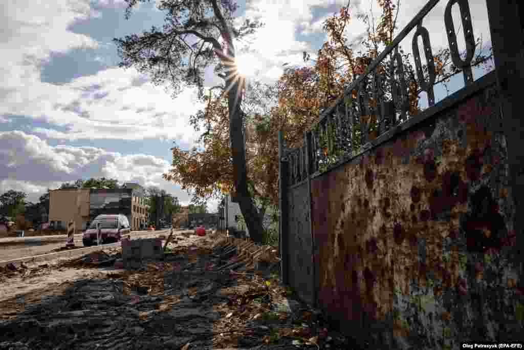 Працівники відновлюють зруйновану дорогу в Ірпені, 23 жовтня 2023 року. За оцінками Світового банку, Україні знадобиться понад 410 мільярдів доларів, щоб відбудувати всю країну