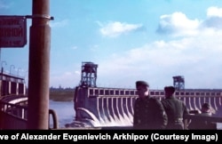 Нацистские военные наблюдают, как вода переливается через плотину