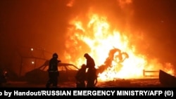 Zjarrfikësit duke u munduar ta shuajnë zjarrin në një pompë të karburanteve në Dagestan, Rusi, 14 gusht 2023.