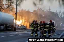 Pompierii cară o persoană rănită de exploziile din fosta stație GPL din Crevedia.