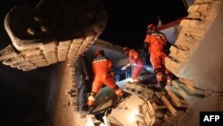 Spasioci među ruševinama u potrazi za preživjelima i nastradalima, selo Kangdiao village, provincija Gansu, 19. decembra 2023.