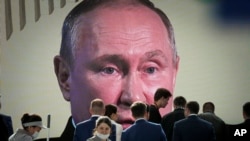 Президент России Владимир Путин (на экране) во время выступления на Санкт-Петербургском международном экономическом форуме, РФ, 17 июня 2022 года