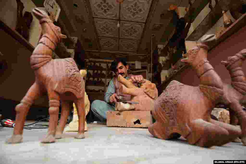 Мастер Захид Али вырезает декоративных деревянных животных в мастерской в Пешаваре, Пакистан.