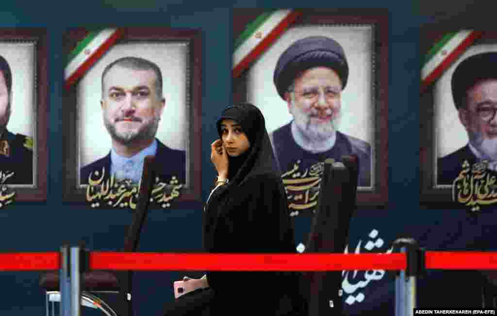 Novinarka sjedi ispred slika pokojnog iranskog predsjednika Ebrahima Raisija i pokojnog ministra vanjskih poslova Hosseina Amir-Abdollahiana tijekom prvog dana registracije za predsjedničke izbore u Ministarstvu unutarnjih poslova u Teheranu, 30. maja 2024.