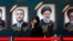 A journalist sits in front of the pictures of late Iranian President Ebrahim Raisi (right) and other officials during the first day of registration for the presidential election at the Interior Ministry in Tehran on May 30.