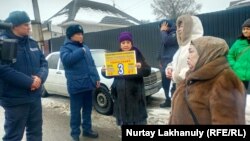 Казахстанские полицейские и активисты, требующие освобождения родных в Синьцзяне, на улице, прилегающей к зданию консульства Китая. Алматы, 8 февраля 2024 года