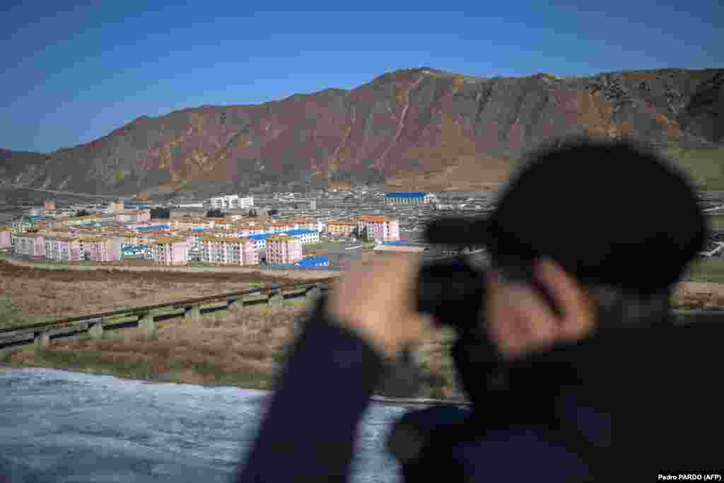 Ova fotografija snimljena u februaru 2024. prikazuje čovjeka koji gleda ka sjevernokorejskom gradu Namyang, iz grada Tumena u sjeveroistočnoj kineskoj provinciji Jilin.