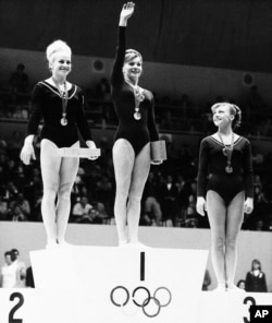 Czechoslovakia's Vera Caslavska (left) and Larissa Petrik from Russia (center) share the winner's podium position after tying for first place in women's floor gymnastics at the 1968 Olympics in Mexico City.