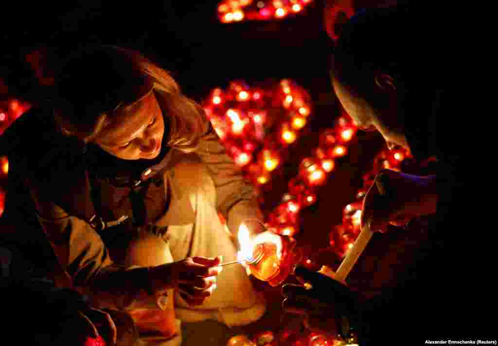  People light candles during a vigil in memory of the 143 victims of a shooting attack at the Crocus City Hall concert venue outside Moscow. 