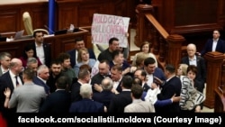  Deputații de la Blocul Comuniștilor și Socialiștilor au blocat tribuna Parlamentului cu bannere și au cerut alegeri anticipate.