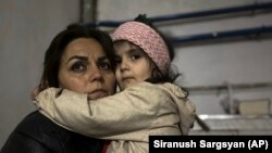 A girl embraces her relative sitting in a shelter during shelling in Stepanakert, September 19, 2023.