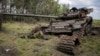 Orosz katona holtteste egy kilőtt tank mellett az ukránok által felszabadított Sztorozseve falunál, a Donyecki területen 2023. június 14-én