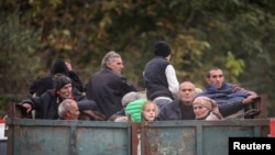 Armenia - Refugees from Nagorno-Karabakh region ride in the back of a truck as they arrive in the border village of Kornidzor, September 26, 2023.