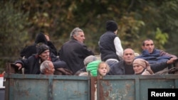 ARMENIA - Refugees from Nagorno-Karabakh ride in the back of a truck as they arrive in the border village of Kornidzor, September 26, 2023.