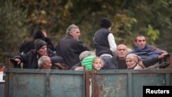 ARMENIA - Refugees from Nagorno-Karabakh ride in the back of a truck as they arrive in the border village of Kornidzor, September 26, 2023.